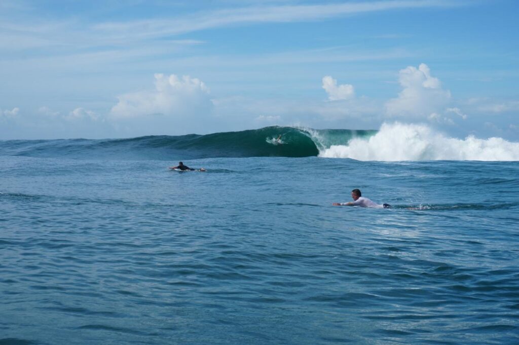 Surfers paddling toward a clean barrel in Salina Cruz, Oaxaca, Mexico